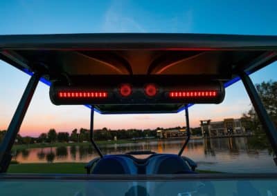 Red lighting from exogear installed on front of roof of golf cart