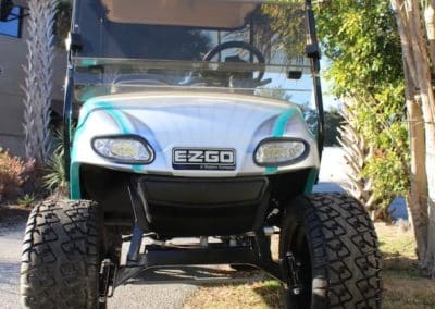 Silver ezgo golf cart with teal accents and a custom lift