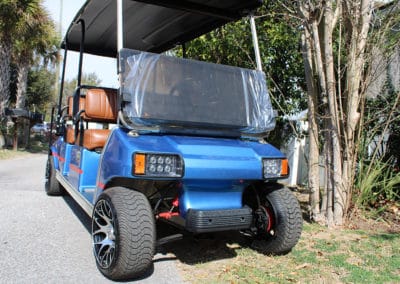 A custom 6-seater golf cart with blue body paint and leather-colored brown upholstery