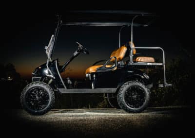 Black golf cart with tan leather seats at dusk