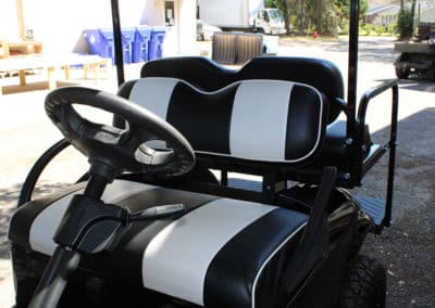 Black golf cart seats customized with white stripes and edging