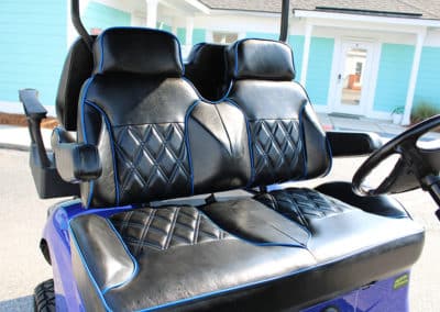 Luxury black golf cart seats with bright blue edging and black armrests and headrests
