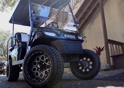 Black golf cart with custom wheels