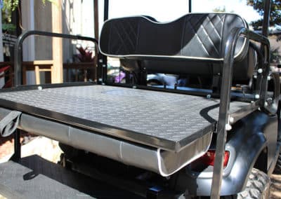 Golf cart jumpseat flips open to become deck