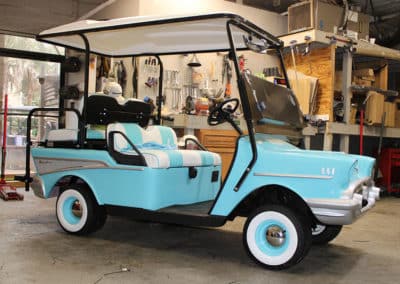 A golf cart totally customized to mimic a classic baby blue T-Bird from custom body panels to the wheels and tires